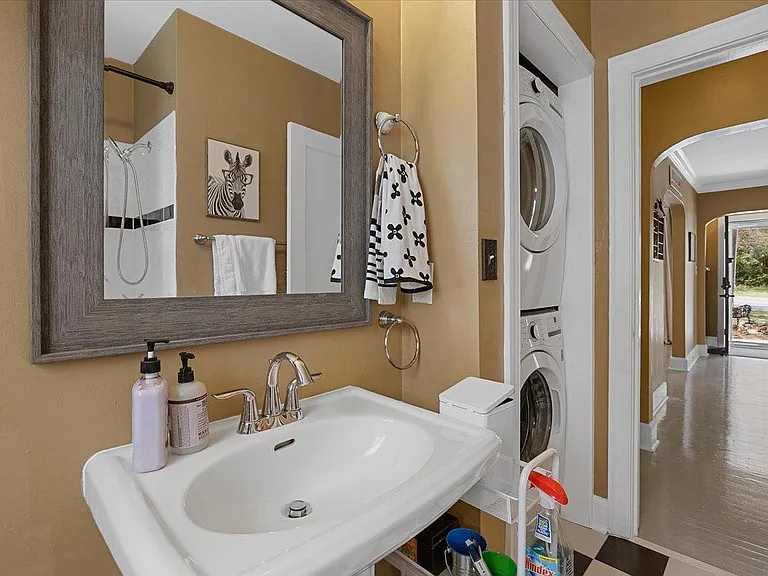 Modern bathroom at Hunsucker's Place, featuring updated fixtures, a full shower, and ample natural light. Conveniently located near Downtown Greensboro and Cone Health Hospital, this space combines functionality and comfort in a central, historic home.