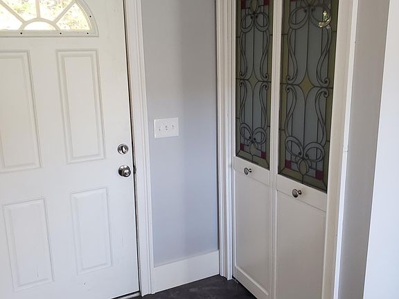 Second floor back door into large eat in dining room with coat clay and storage bench with coat hooks.