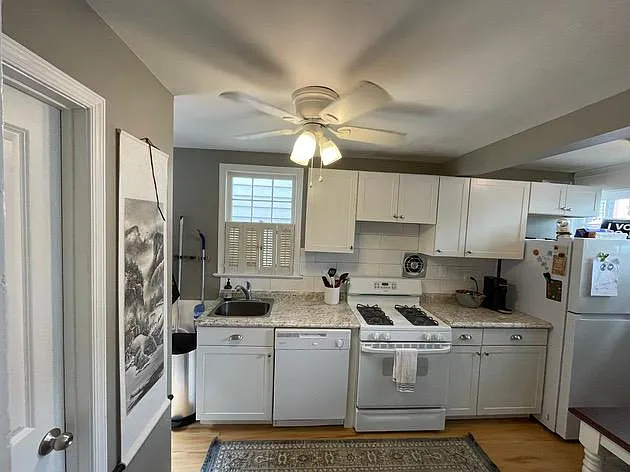Kitchen with gas stove, exhaust fan, dishwasher, disposal. Windows to Wolfe Street, over sink, and patio door.