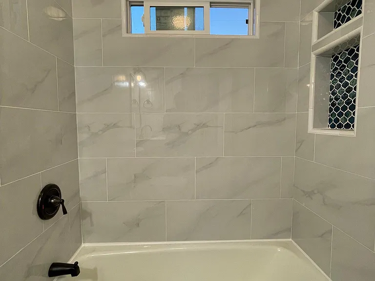 Bath tiles, niche and shower fixtures all new