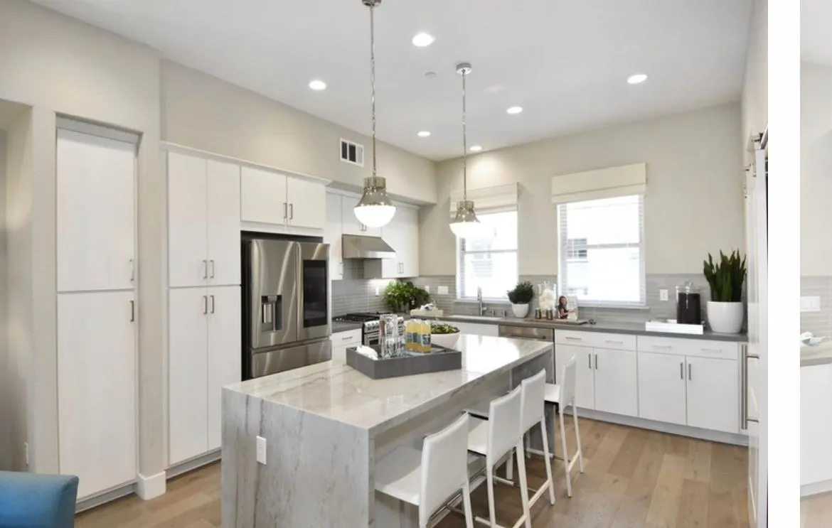 Open floorplan chefs kitchen with quartz countertops and white cabinetry - 1709 Hazelnut Ln