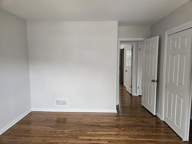Primary bedroom continued. Freshly painted, bright and finished hardwood floors.