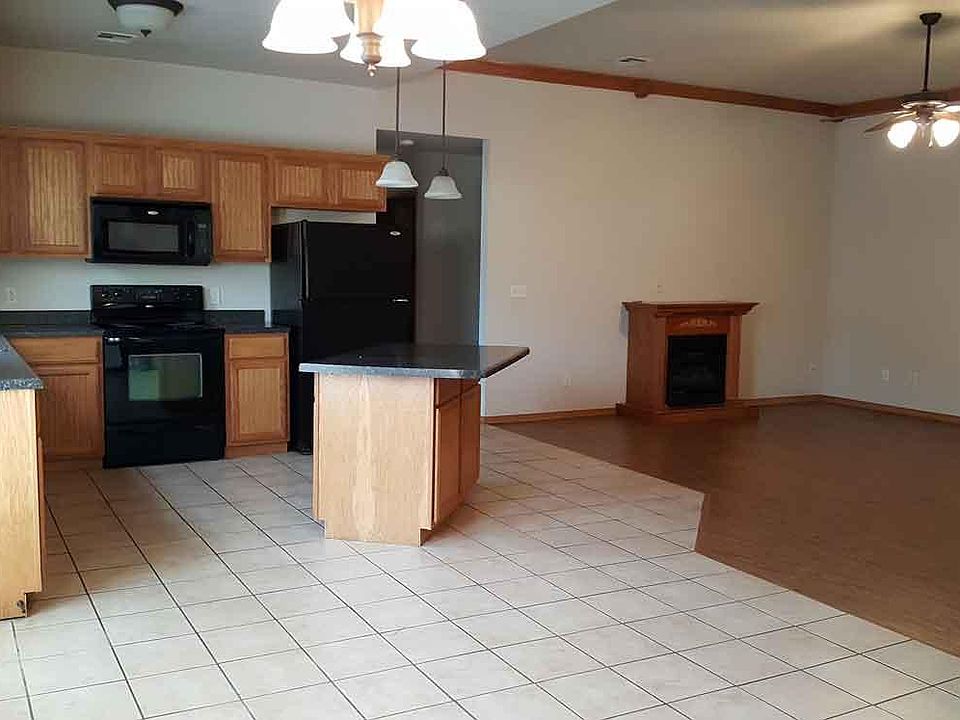 Kitchen with island and appliances included, gas fireplace in living room.