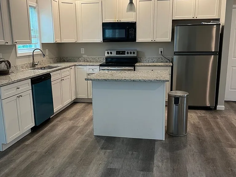 Kitchen with a dishwasher, stove, microwave, and refrigerator