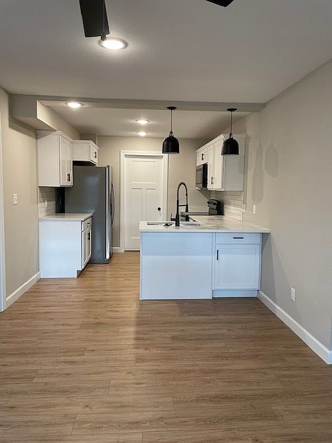 Kitchen featuring luxury vinyl plank, quartz countertops and stainless steel appliances