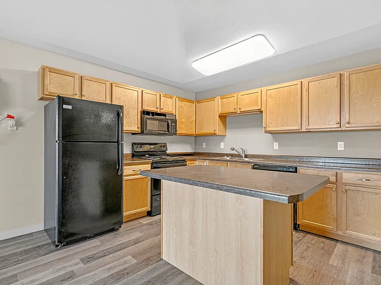 Elevate your lifestyle at Minot Place Apartments with this stunning kitchen featuring modern appliances, ample counter space, and a spacious layout. Perfect for culinary enthusiasts and gatherings alike. Schedule your tour today!