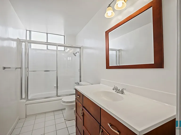 Bathroom with a Shower-Bath with a Glass Door and VAnity Cabinet Storage and Drawers