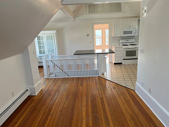 View from far side of living/family room to kitchen and then bedroom