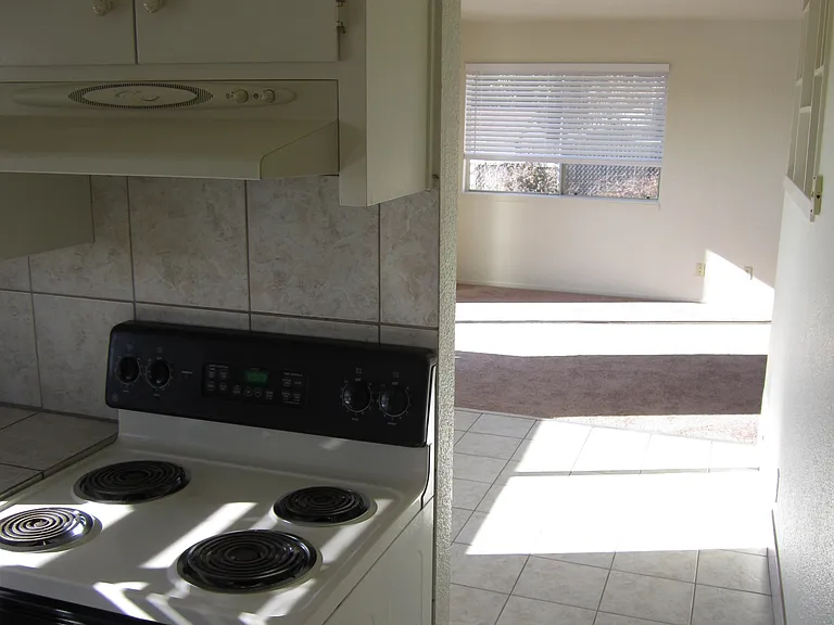 Exit kitchen to spacious tiled flooring dining room with ceiling fan
