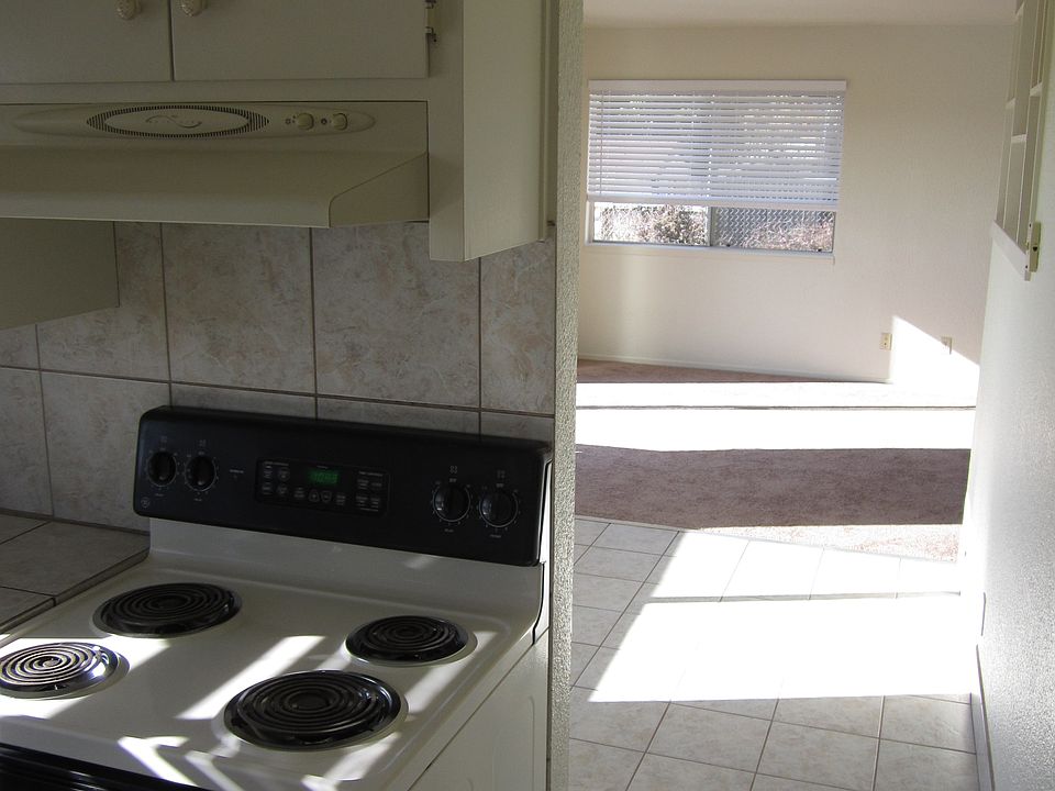 Exit kitchen to spacious tiled flooring dining room with ceiling fan