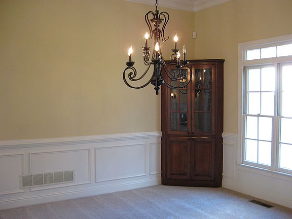 Dining room has built-in cherry corner china cabinet, new bronze chandelier.