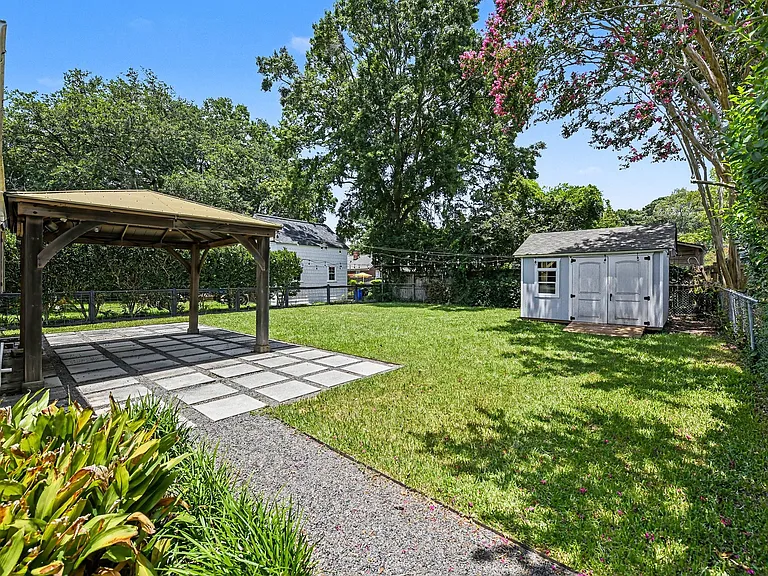 Spacious, fully fenced-in backyard with veranda and large storage shed