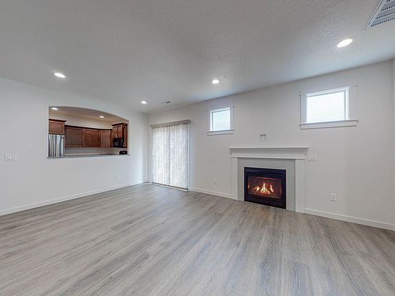 Living area with gas fireplace, opening to kitchen & slider to patio