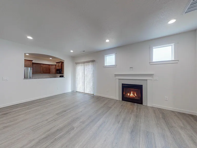 Living area with gas fireplace, opening to kitchen & slider to patio