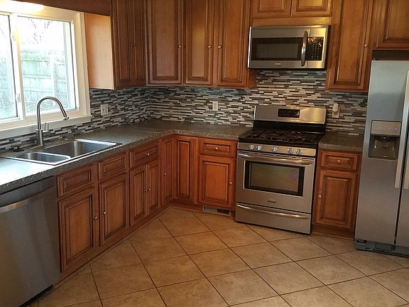 Updated kitchen with concrete counter tops and stainless steel appliances.