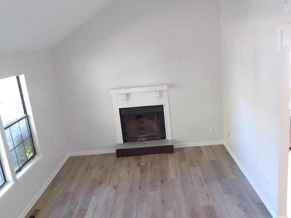 Living room freshly painted, new luxury vinyl on floor, new tile at wood burning fire place