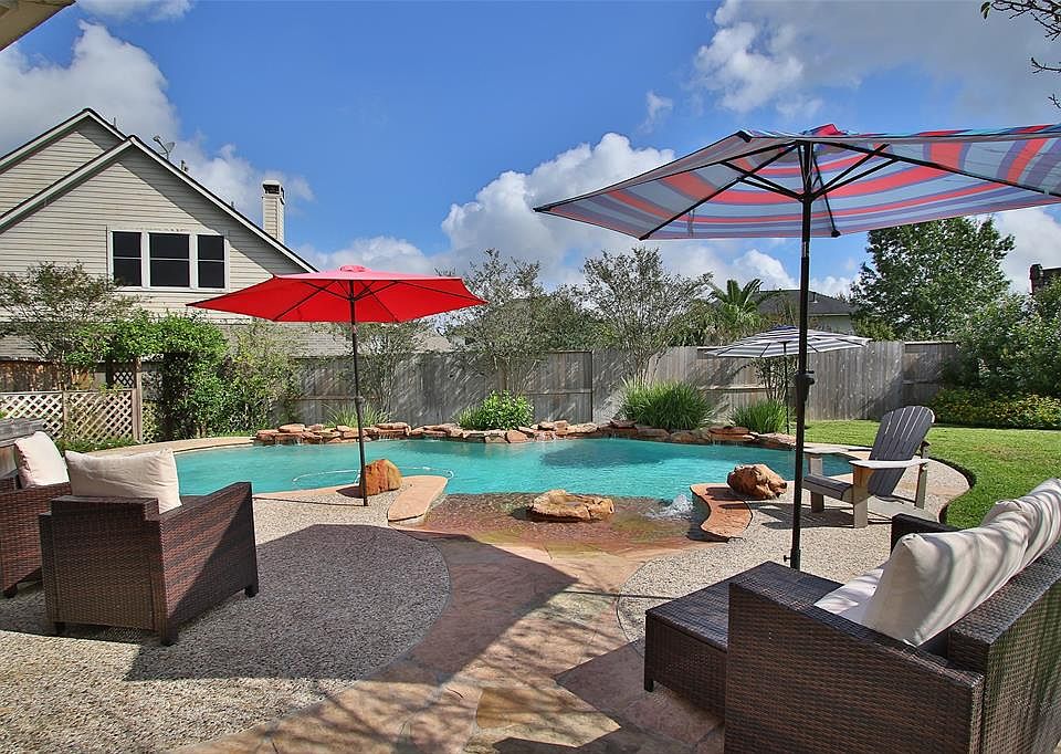Beach entry chlorine pool with waterfalls and umbrella fittings in pool.
