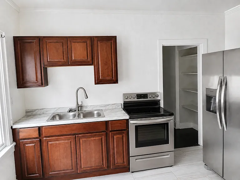 Kitchen with Refrigerator, Stove, and Pantry Space