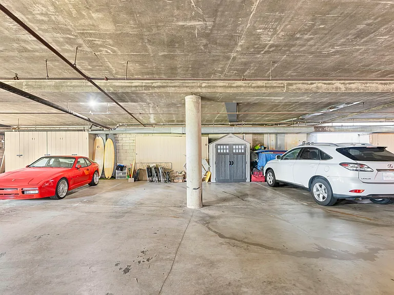 Condo has 2 assigned side-by-side parking spaces under the building in communal parking garage and a large wooden storage shed built-in behind the left parking space