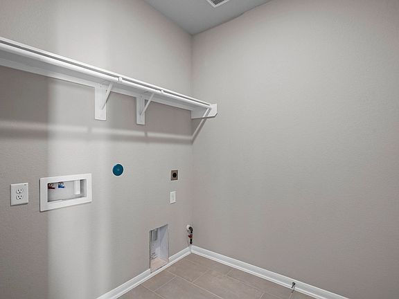Organized and practical space featuring a large shelf and laundry connections.