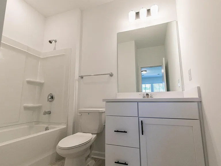 Bathroom including single vanity with a tub and shower combo.
