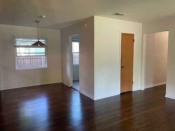 Front door entrance on right, and dining room space on left. Newly resurfaced hardwood floors!
