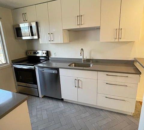 Kitchen showing quartz countertop and new stove and dishwasher and microwave all included
