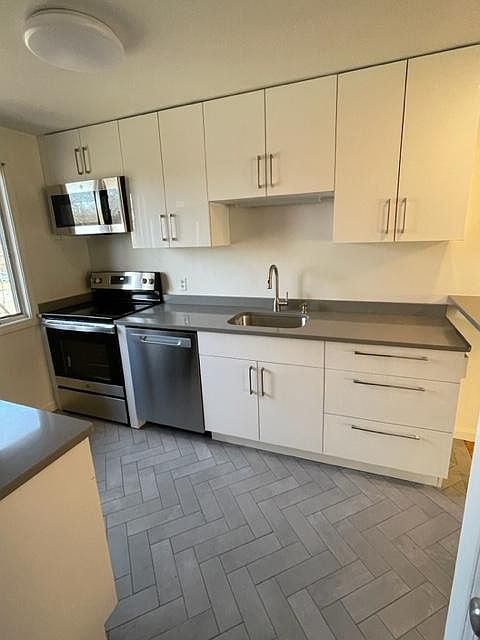 Kitchen showing quartz countertop and new stove and dishwasher and microwave all included