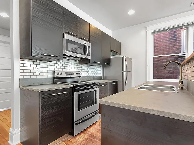 Kitchen - salvaged hardwood floors, stainless steel appliances, tiled backsplash, venetian blinds