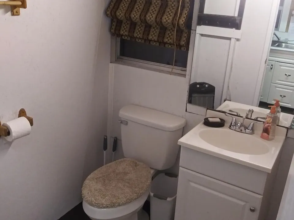 BATH ROOM HAS NEW CHAIR HEIGHT ELONGATED TOILET AND NEW SEAT COVER AND FLOOR CARPETS.