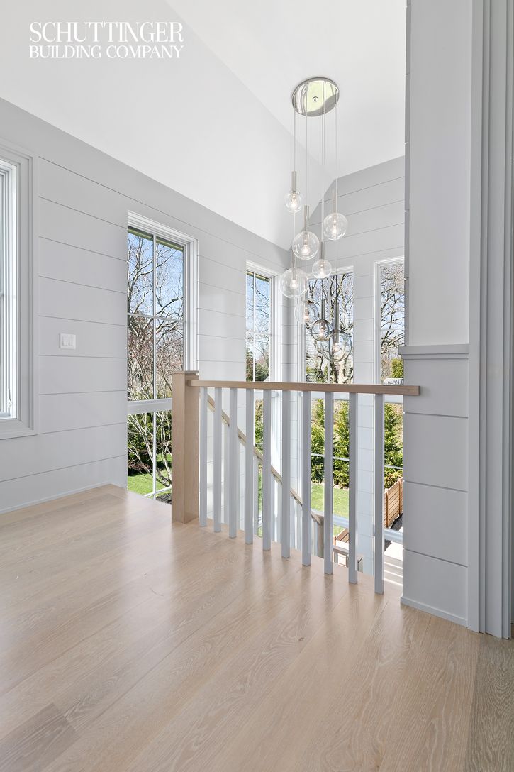  Rear Staircase with Chandelier, High Gloss Shiplap Paneling and Expansive Bank of Windows 
