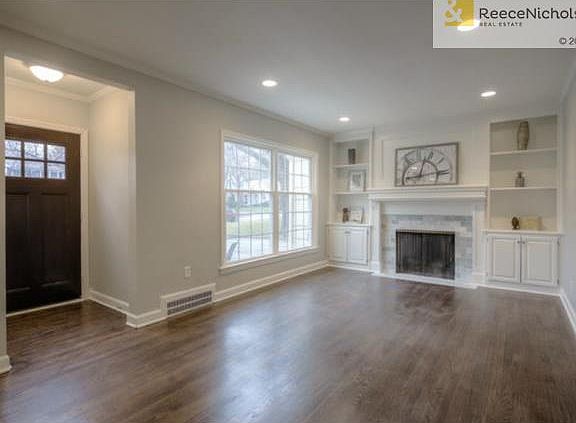 Dark walnut stained hardwood floors with marble tile around the