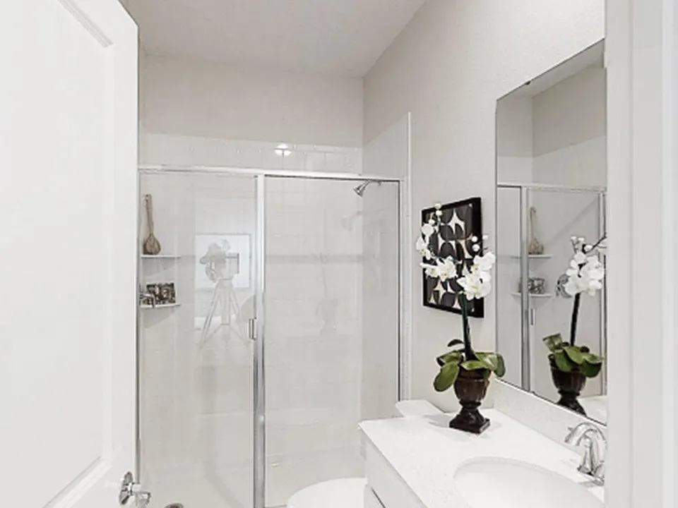 Accessible from the bedroom, the full-sized bathroom features a glass-enclosed shower and high-end vanity