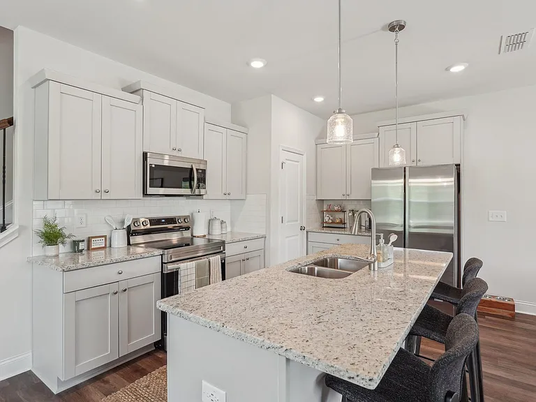 Kitchen featuring a sleek granite countertop and a convenient sink.
