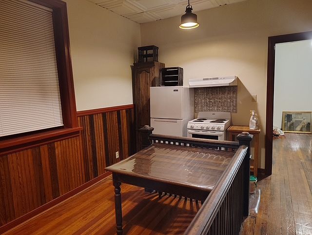 This photo shows the kitchen table and the beautiful hardwood floors and wainscot.