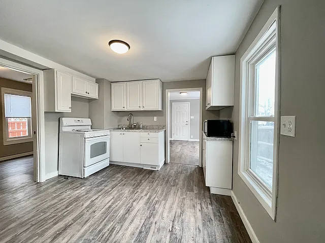 Kitchen with refrigerator, range/oven, microwave, and updated counters and sink.