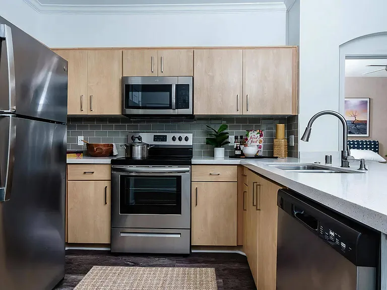 Contemporary Kitchen with Light Wood Cabinets and Built-In Microwave