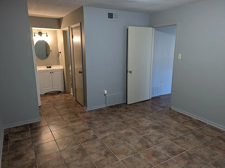 View of bedroom facing the vanity area and the door that goes into the living room.
