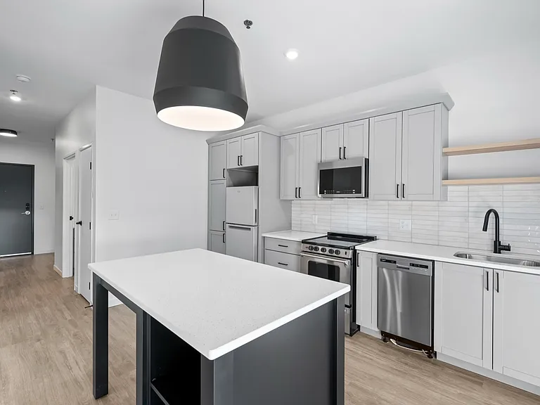 Modern kitchen with sleek cabinetry, stainless steel appliances, and a spacious island under elegant lighting. Modern kitchen with sleek cabinetry, stainless steel appliances, and a spacious island under elegant lighting.