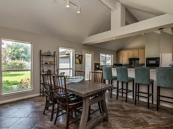 Adjacent to living area is the high breakfast bar and dining area. There is so much natural light flowing into this space!
