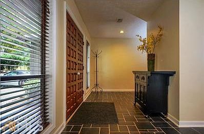 Foyer just inside double wood door has passage way on either side to vaulted family room.