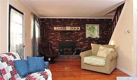 Recently renovated livingroom with new hardwood floors & fireplace with woodstove insert.