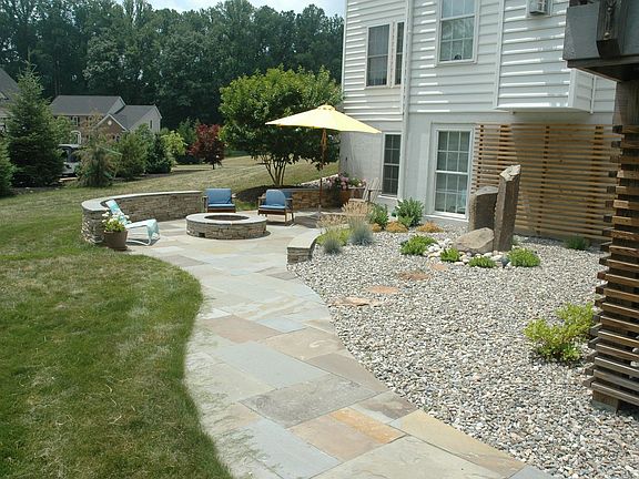Stone firepit & walls, landscape lighting & fountain are lovely features