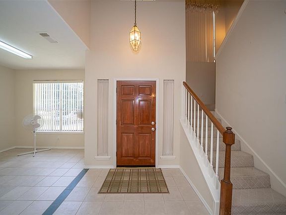 Looking at the interior front door, there's a formal dining or additional living space to the left, opposite the stairs.