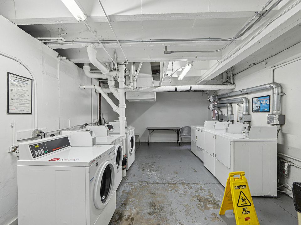 Laundry room with a row of washing machines and dryers