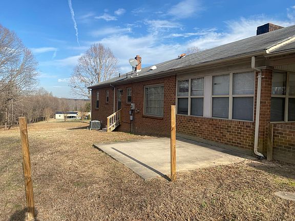 Back of house has an entrance and concrete pad for patio/grill area