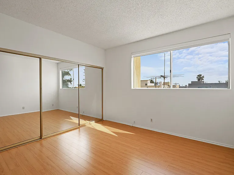 Bedroom with Large Mirrored Closet, Vinyl Flooring, and Windows