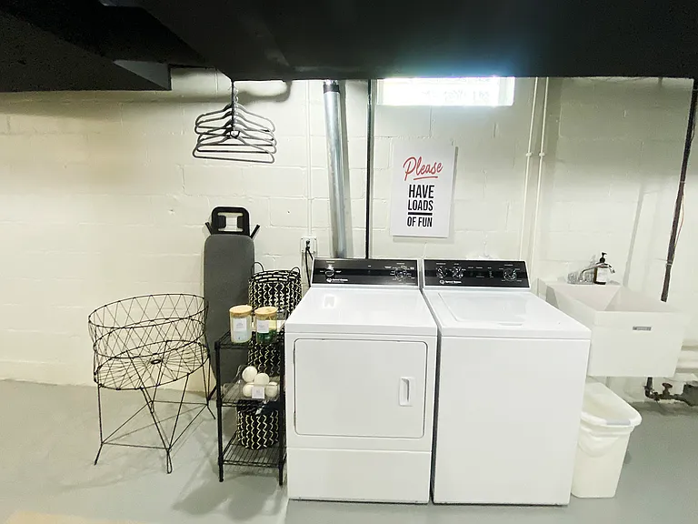 The laundry area includes washer, dryer, ironing board, iron, clothes drying rack (not pictured) and starter detergent.