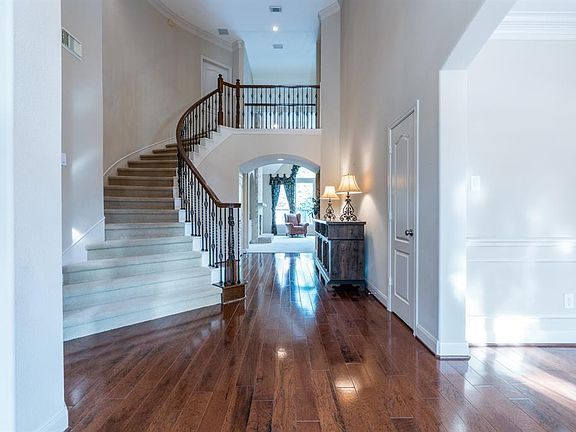 Upon entering this home, you step into the open foyer with a stunning winding staircase with iron railings! Beautiful hardwood hickory flooring flows into the formal dining room, living room, and down the hallway towards the family room!