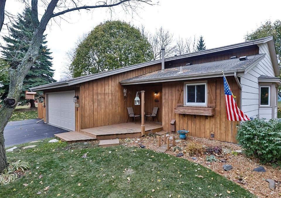 Front of Home with beautiful trees, landscaping, and covered front porch